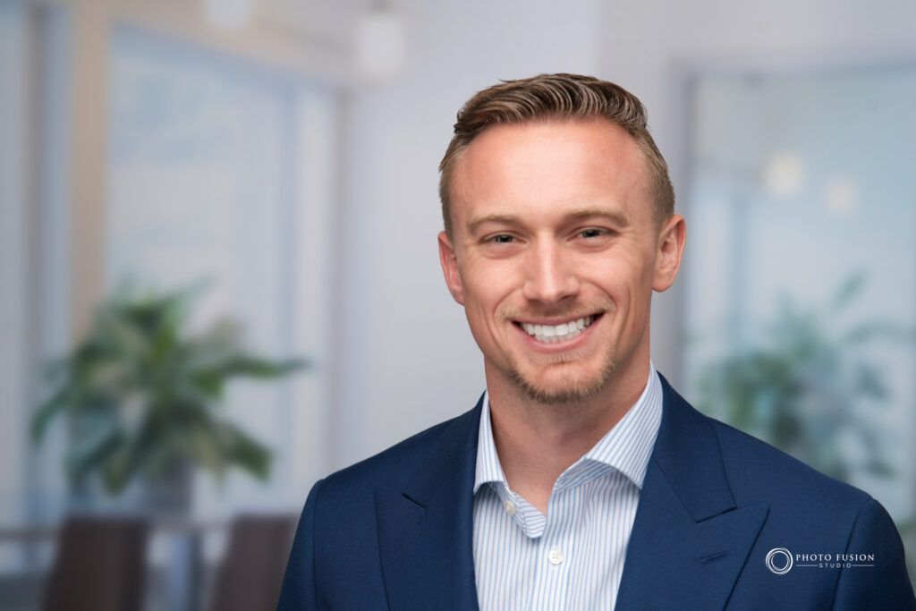 Man smiling at the camera getting his headshot taken at a headshot station.
