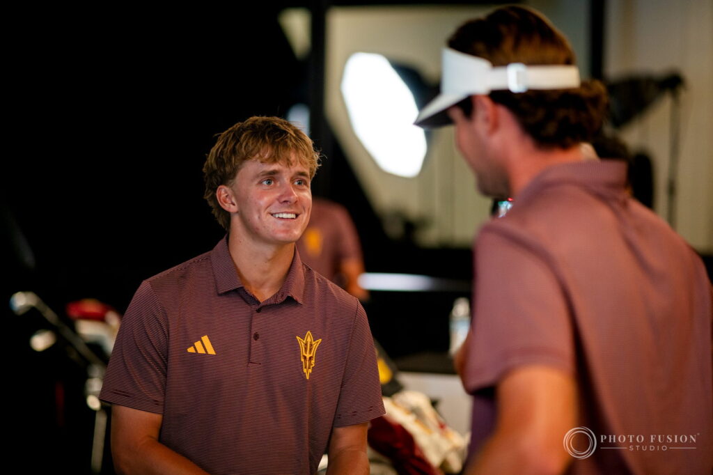 An ASU men's golf player smiles in conversation with a lighting softbox glowing behind him
