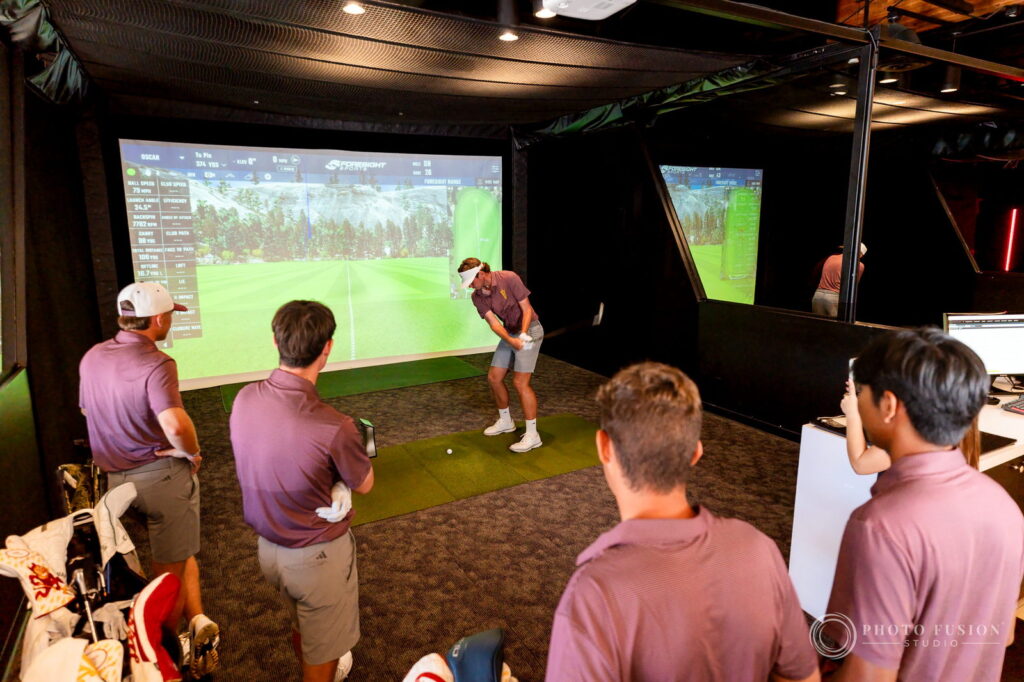 ASU men's golf teammates watch one player hit into the simulator during his True Spec fitting