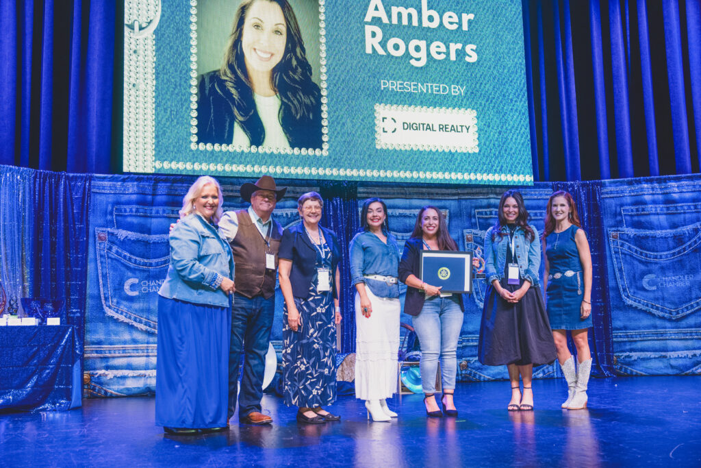 Amber Rogers accepts the Support Staff of the Year award on stage with presenters at the Chandler Chamber Community Awards