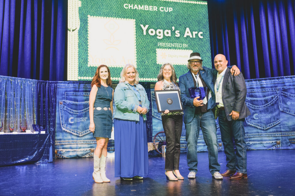 Kary and Robert Sinkule of Yoga's Arc accept the Chamber Cup on stage at the Chandler Chamber Community Awards