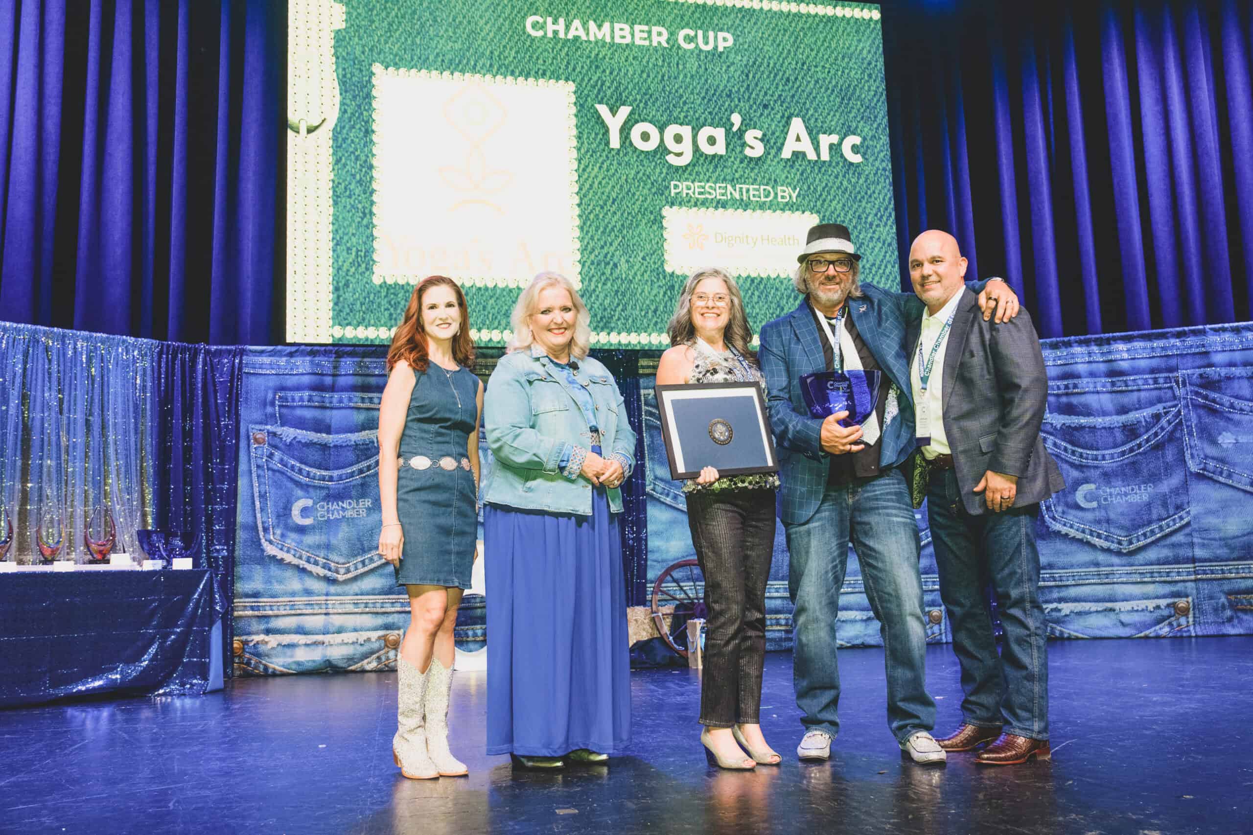 Kary and Robert Sinkule of Yoga's Arc accept the Chamber Cup on stage at the Chandler Chamber Community Awards
