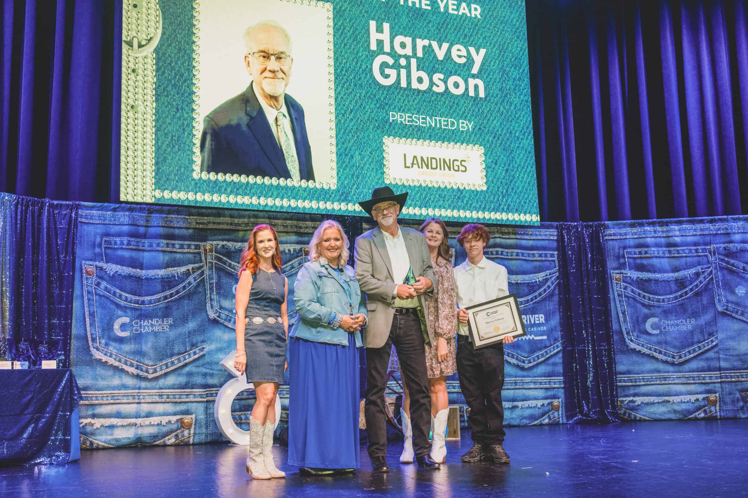 Harvey Gibson accepts the Ambassador of the Year award on stage with family at the Chandler Chamber Community Awards