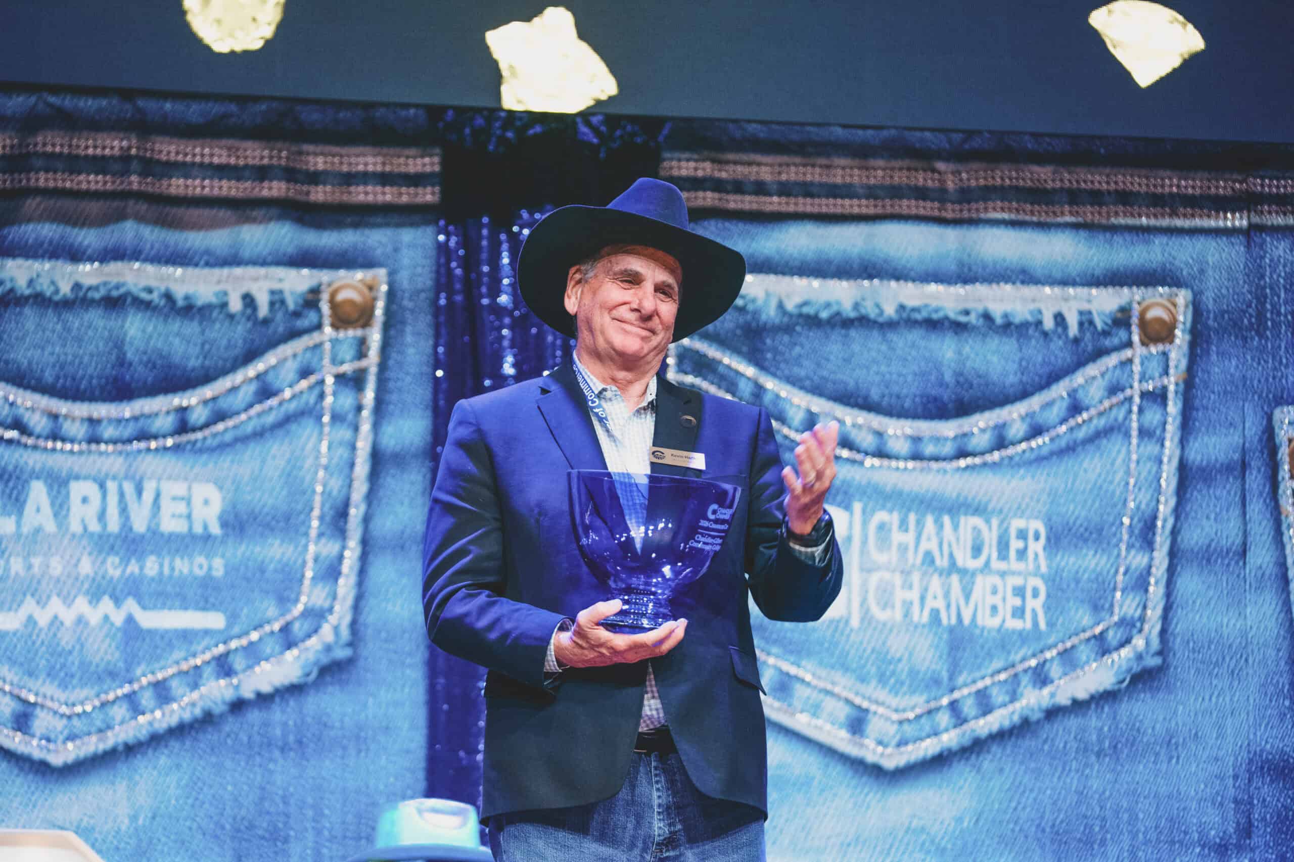Chandler Mayor Kevin Hartke holds the Chandler Cup trophy on stage at the Chandler Chamber Community Awards