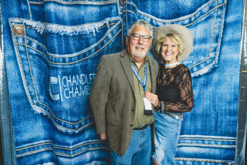 Mike McClanahan of St. Vincent de Paul with a guest at the denim photo backdrop, Chandler Chamber Community Awards