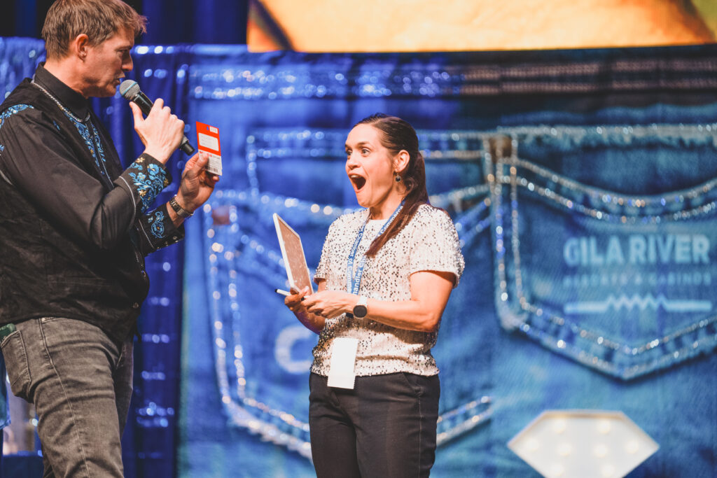 An emcee surprises a guest who reacts with delight during a prize game at the Chandler Chamber Community Awards