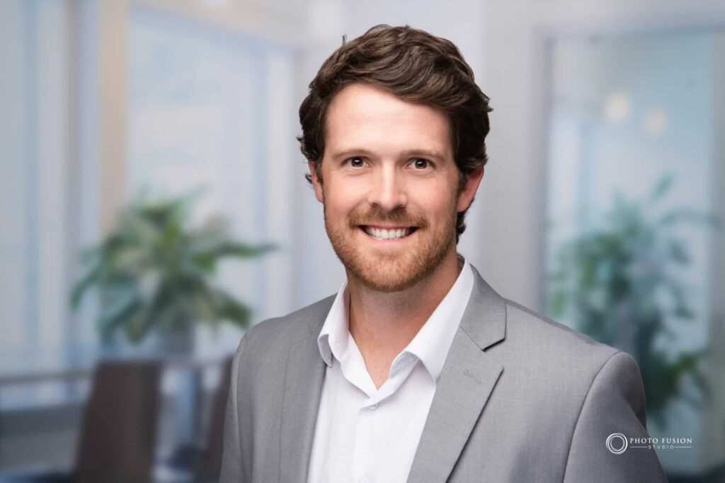 Man smiling at the camera getting his headshot taken at a headshot station.