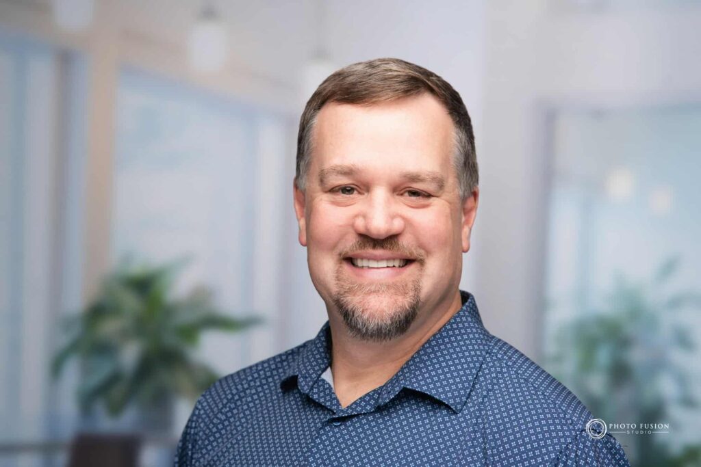 Man smiling at the camera getting his headshot taken at a headshot station.
