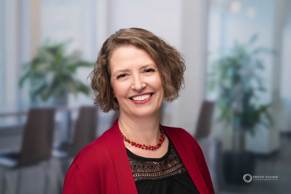 Woman smiling at the camera getting his headshot taken at a headshot station.