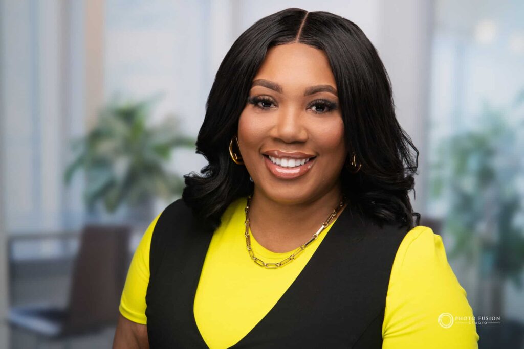 Woman smiling at the camera getting his headshot taken at a headshot station.