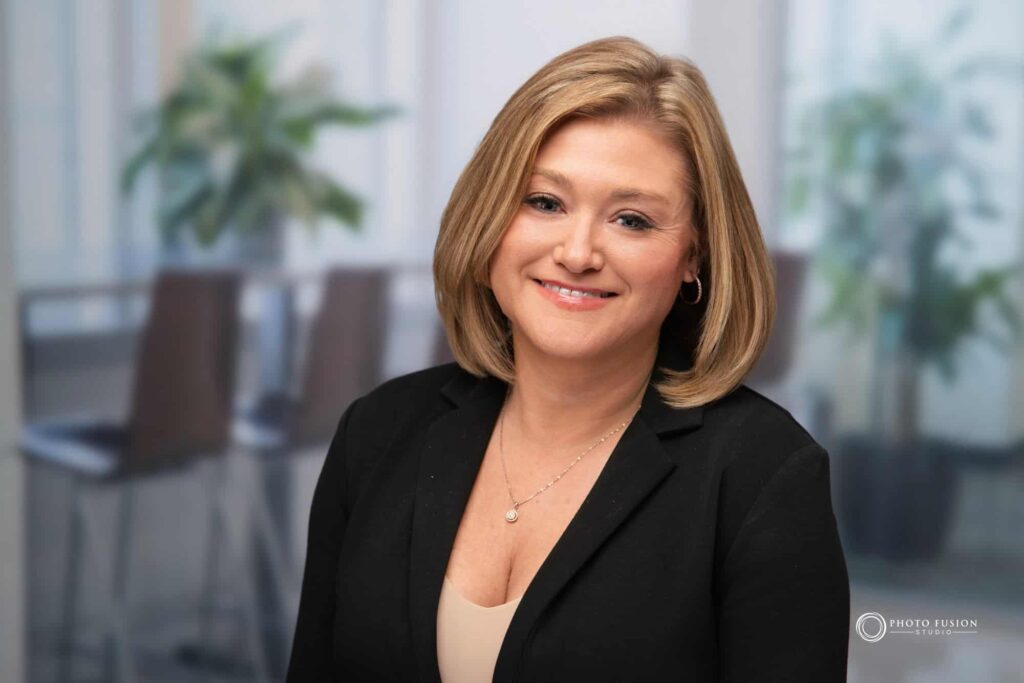Woman smiling at the camera getting his headshot taken at a headshot station.