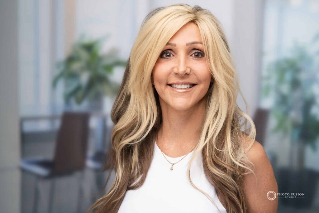 Woman smiling at the camera getting his headshot taken at a headshot station.