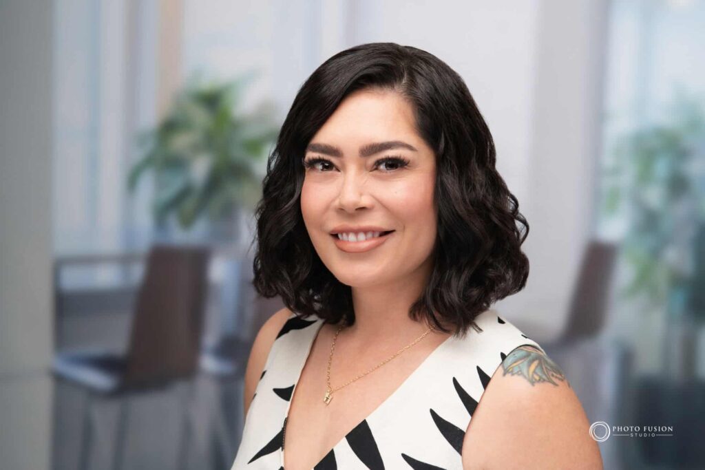 Woman smiling at the camera getting his headshot taken at a headshot station.