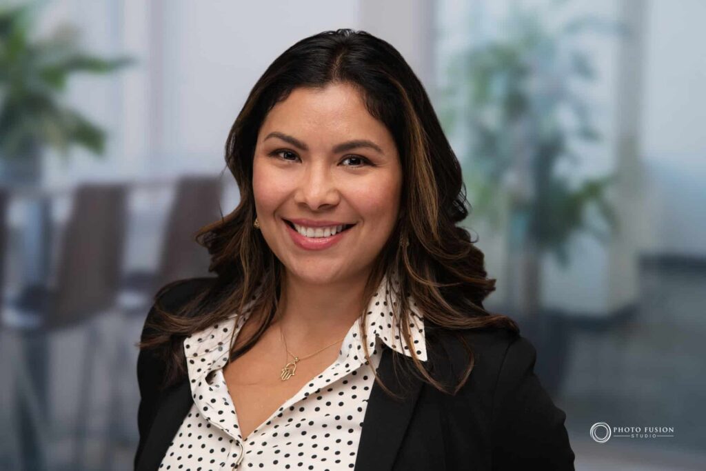 Woman smiling at the camera getting his headshot taken at a headshot station.