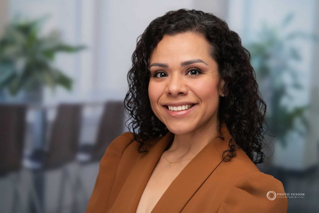 Woman smiling at the camera getting his headshot taken at a headshot station.