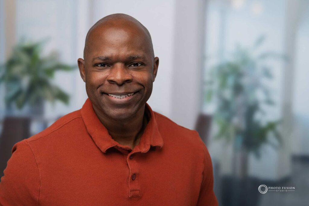 Man smiling at the camera getting his headshot taken at a headshot station.