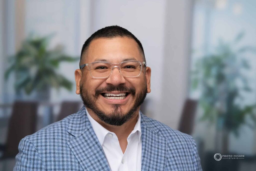 Man smiling at the camera getting his headshot taken at a headshot station.