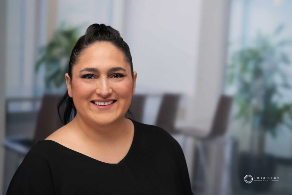Woman smiling at the camera getting his headshot taken at a headshot station.