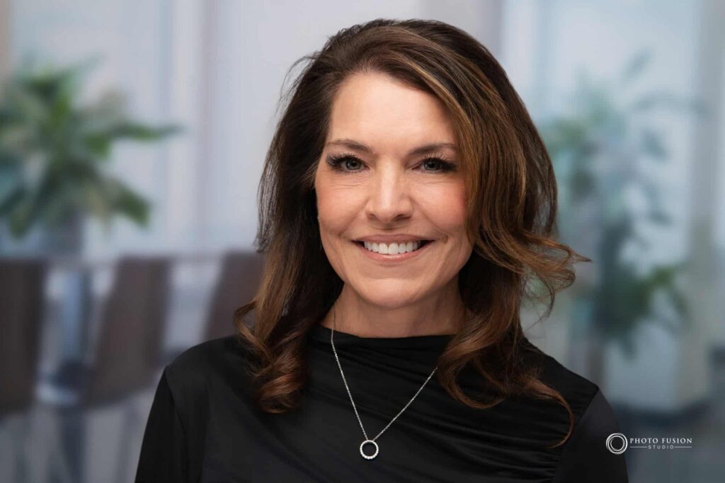 Woman smiling at the camera getting his headshot taken at a headshot station.
