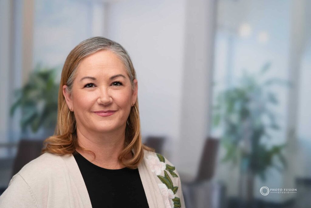Woman smiling at the camera getting his headshot taken at a headshot station.