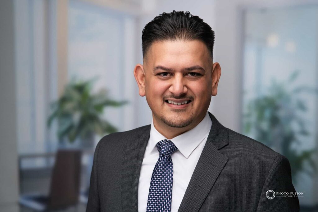Man smiling at the camera getting his headshot taken at a headshot station.
