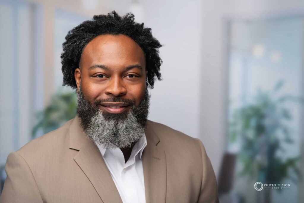 Man smiling at the camera getting his headshot taken at a headshot station.