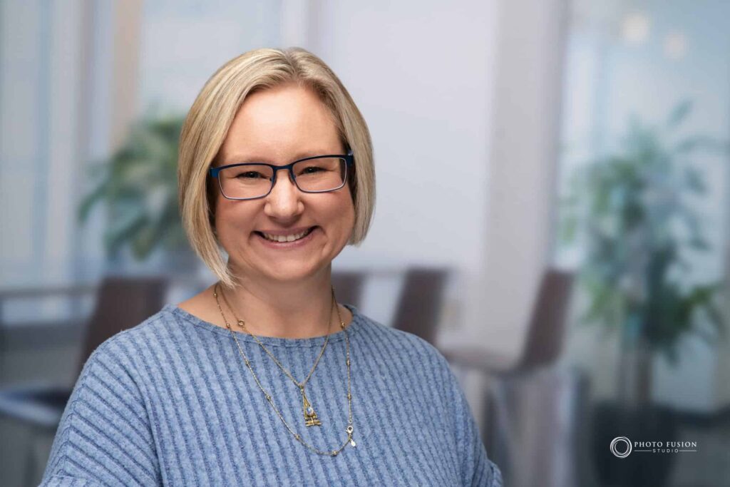 Woman smiling at the camera getting his headshot taken at a headshot station.