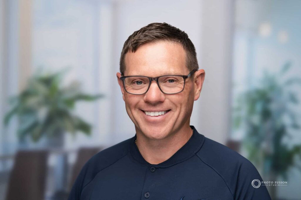 Man smiling at the camera getting his headshot taken at a headshot station.