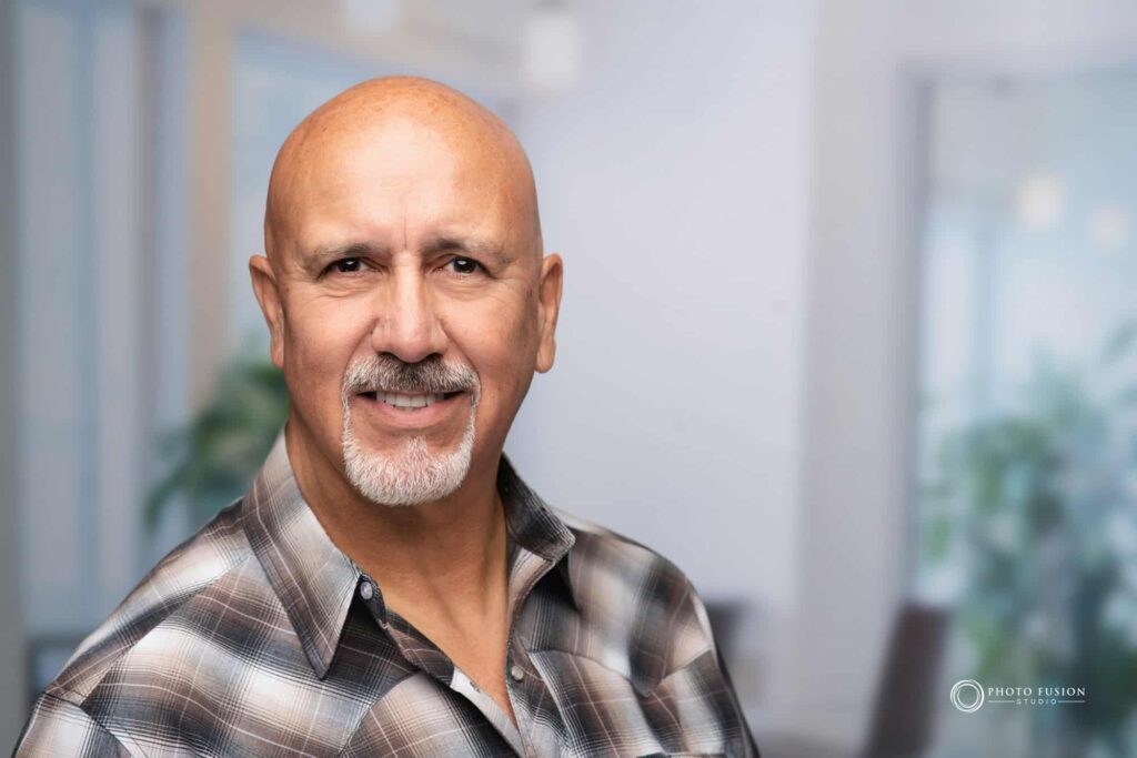 Man smiling at the camera getting his headshot taken at a headshot station.