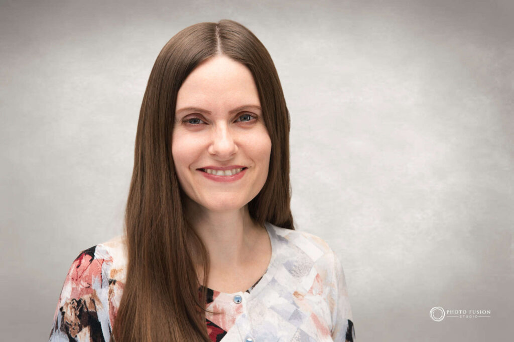 Woman smiling at the camera getting his headshot taken at a headshot station.