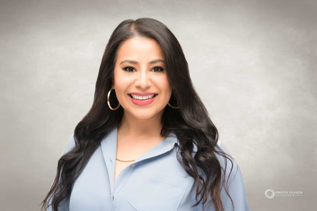 Woman smiling at the camera getting his headshot taken at a headshot station.