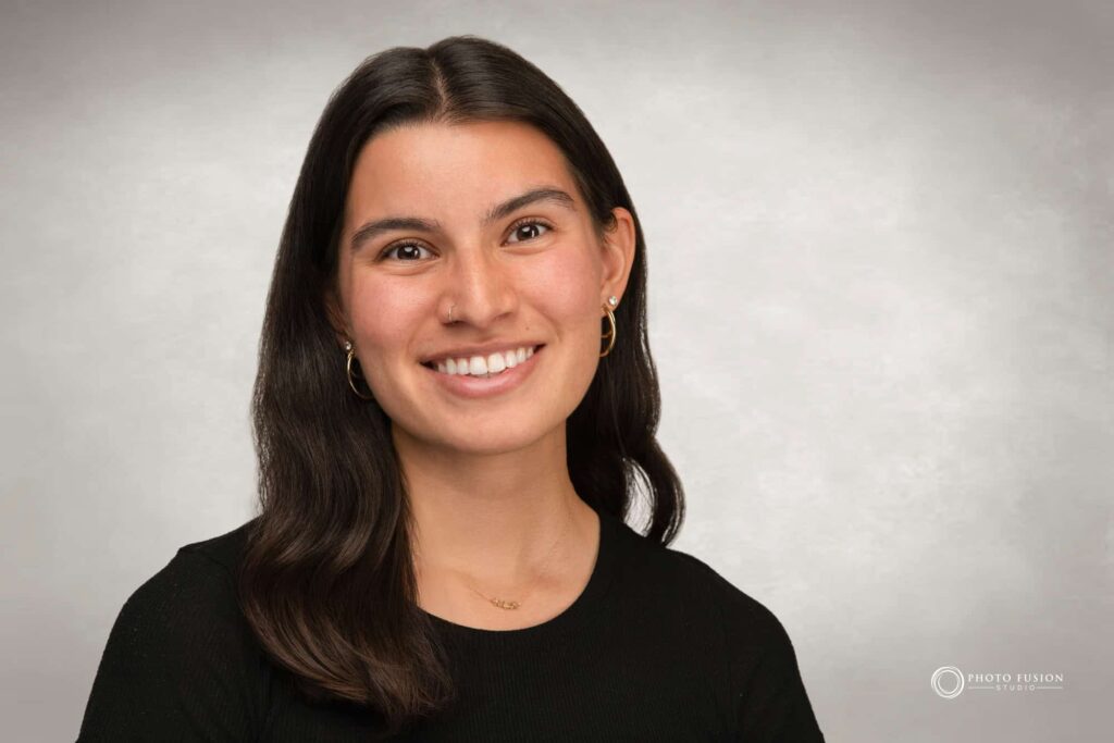 Woman smiling at the camera getting his headshot taken at a headshot station.