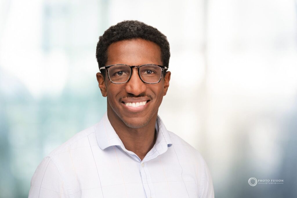Man smiling at the camera getting his headshot taken at a headshot station.