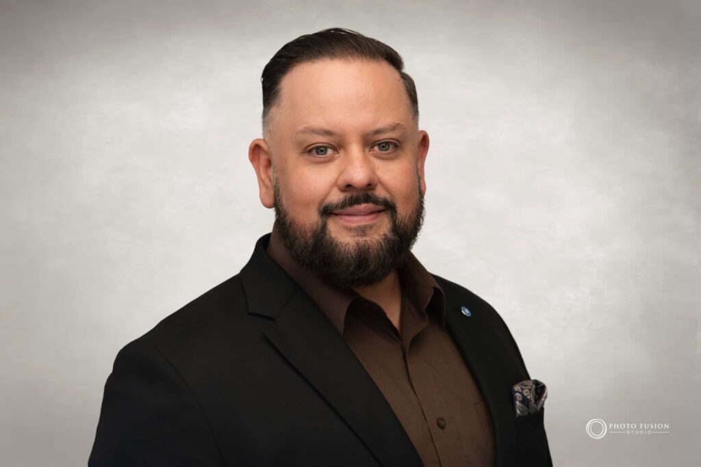 Man smiling at the camera getting his headshot taken at a headshot station.