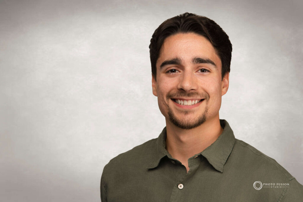 Man smiling at the camera getting his headshot taken at a headshot station.