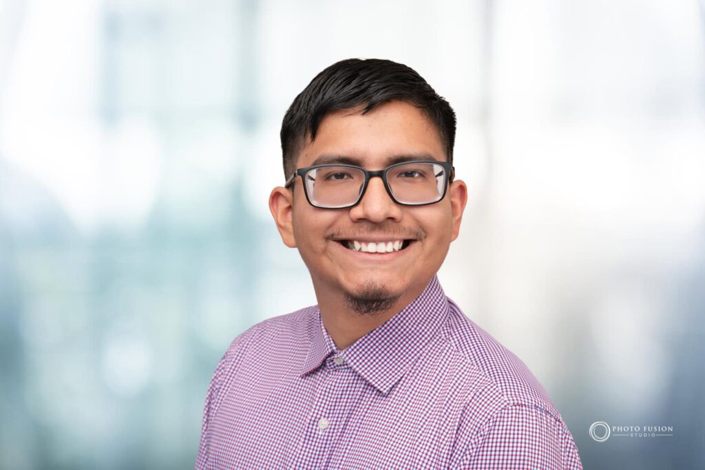 Man smiling at the camera getting his headshot taken at a headshot station.