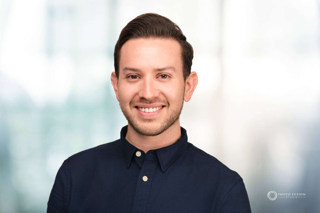 Man smiling at the camera getting his headshot taken at a headshot station.