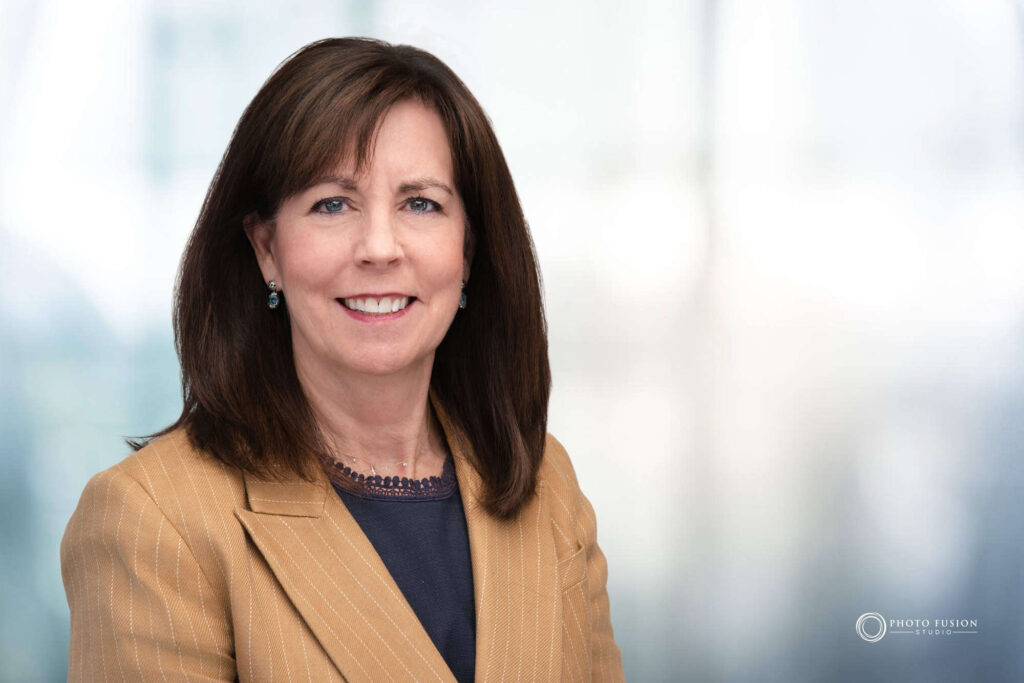Woman smiling at the camera getting his headshot taken at a headshot station.