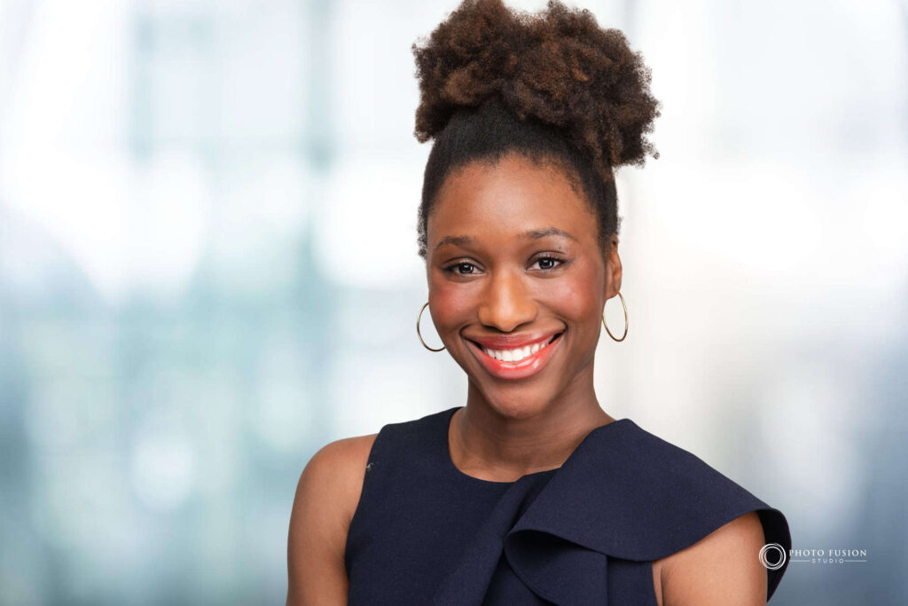 Woman smiling at the camera getting his headshot taken at a headshot station.