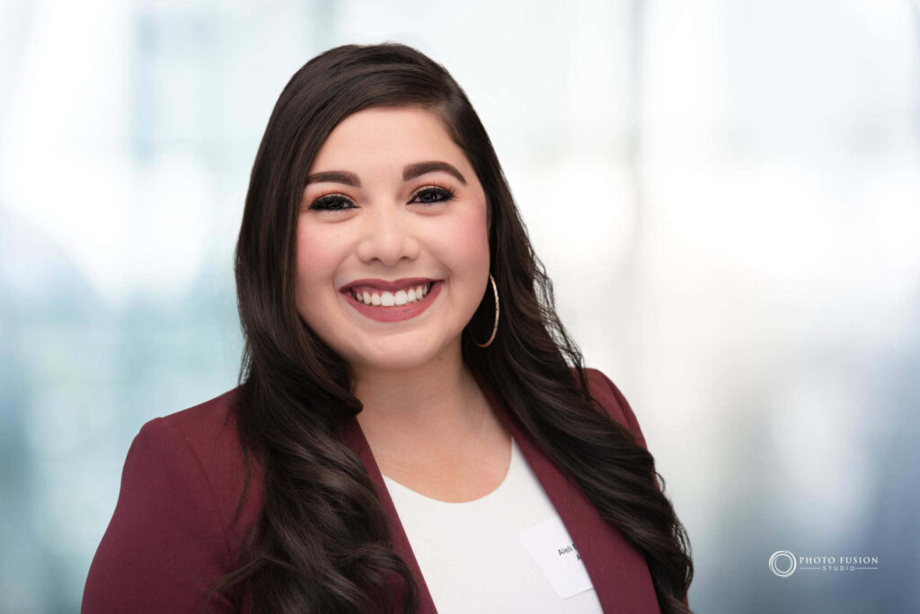 Woman smiling at the camera getting his headshot taken at a headshot station.