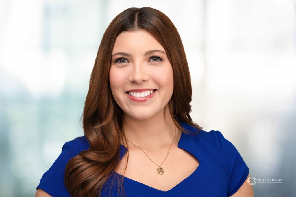 Woman smiling at the camera getting his headshot taken at a headshot station.