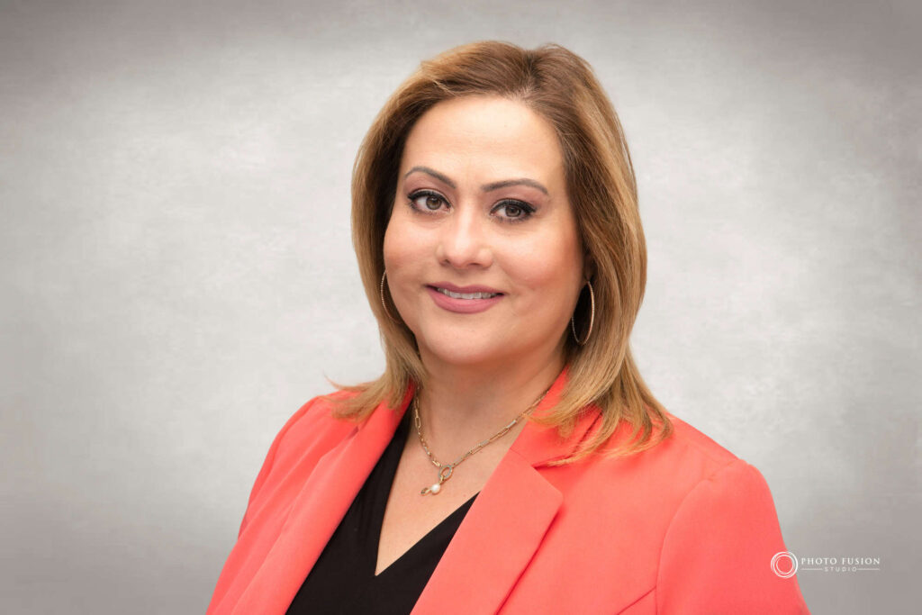 Woman smiling at the camera getting his headshot taken at a headshot station.