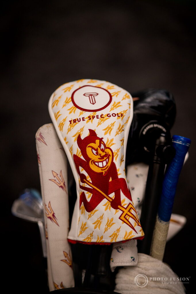 A white True Spec Golf driver headcover printed with gold pitchforks and the ASU Sparky mascot