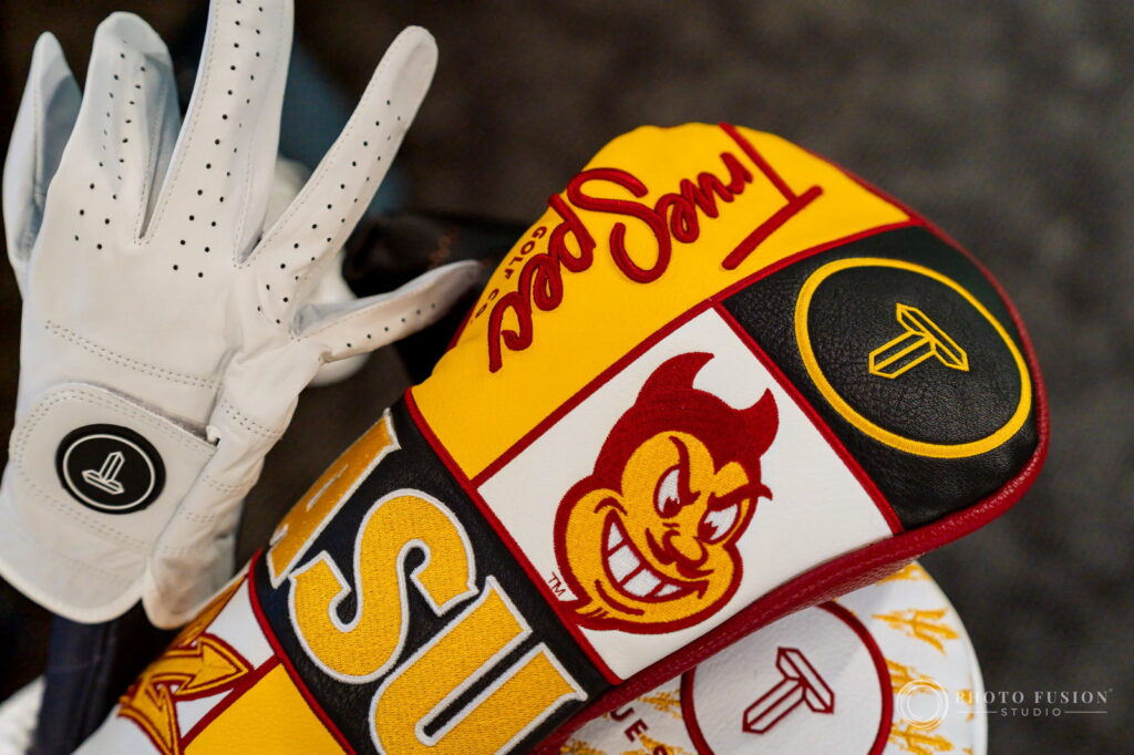 Macro detail of a white True Spec Golf glove resting beside an ASU Sparky headcover on a golf bag