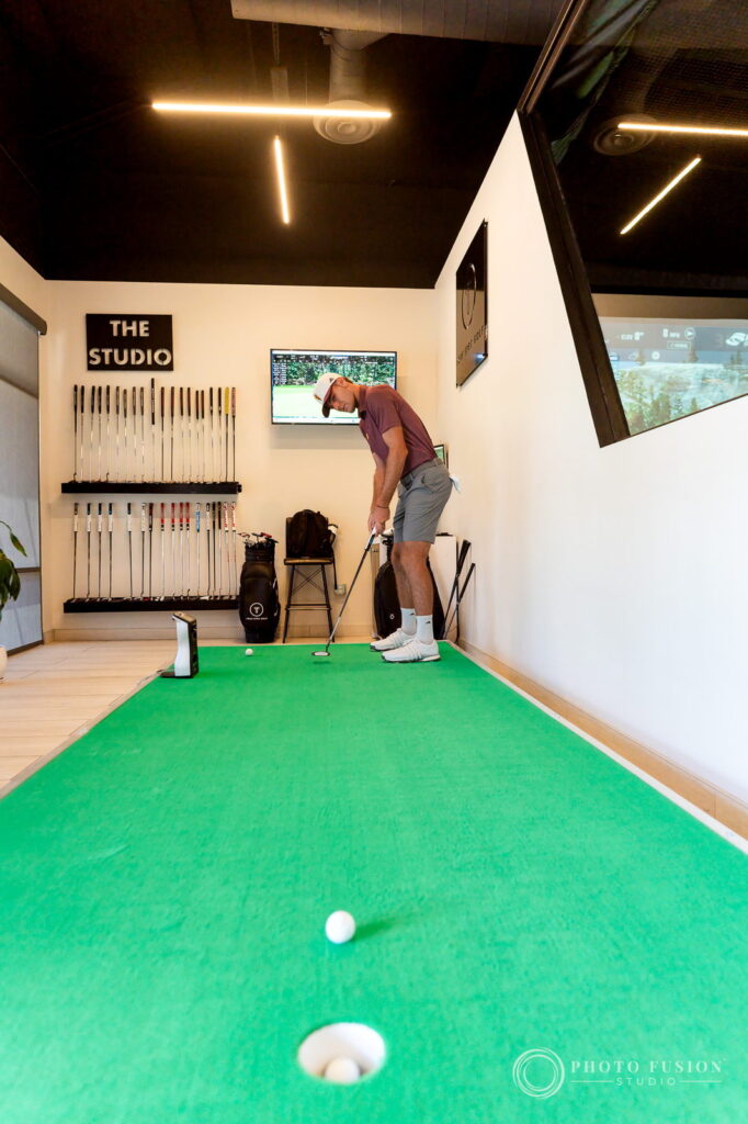 An ASU golfer putts on the indoor green in the putting studio at True Spec Golf Scottsdale