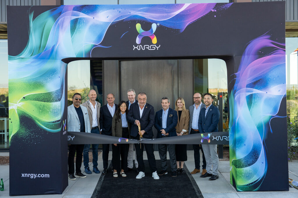 XNRGY CEO Wais Jalali and leadership team posed under the colorful XNRGY entrance arch moments before cutting the ribbon at the Mesa Gateway facility.