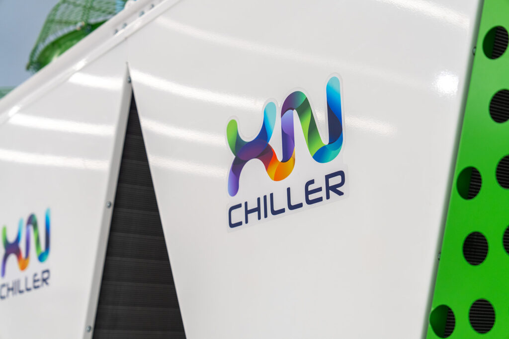 Close-up of the XNRGY XnChiller product branding logo on a white and green chiller unit at the Mesa Gateway open house.